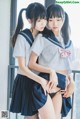 two asian girls in school uniforms posing for the camera