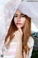 A woman in a white dress with a veil over her head.