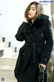 A woman in a black coat with a fur collar.