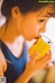 A young girl drinking from a can of soda.