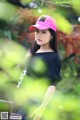 A woman wearing a pink hat sitting on a bench.