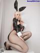 A woman in a bunny costume sitting on a stool.