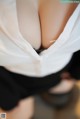 A close up of a woman's breasts in a white shirt.